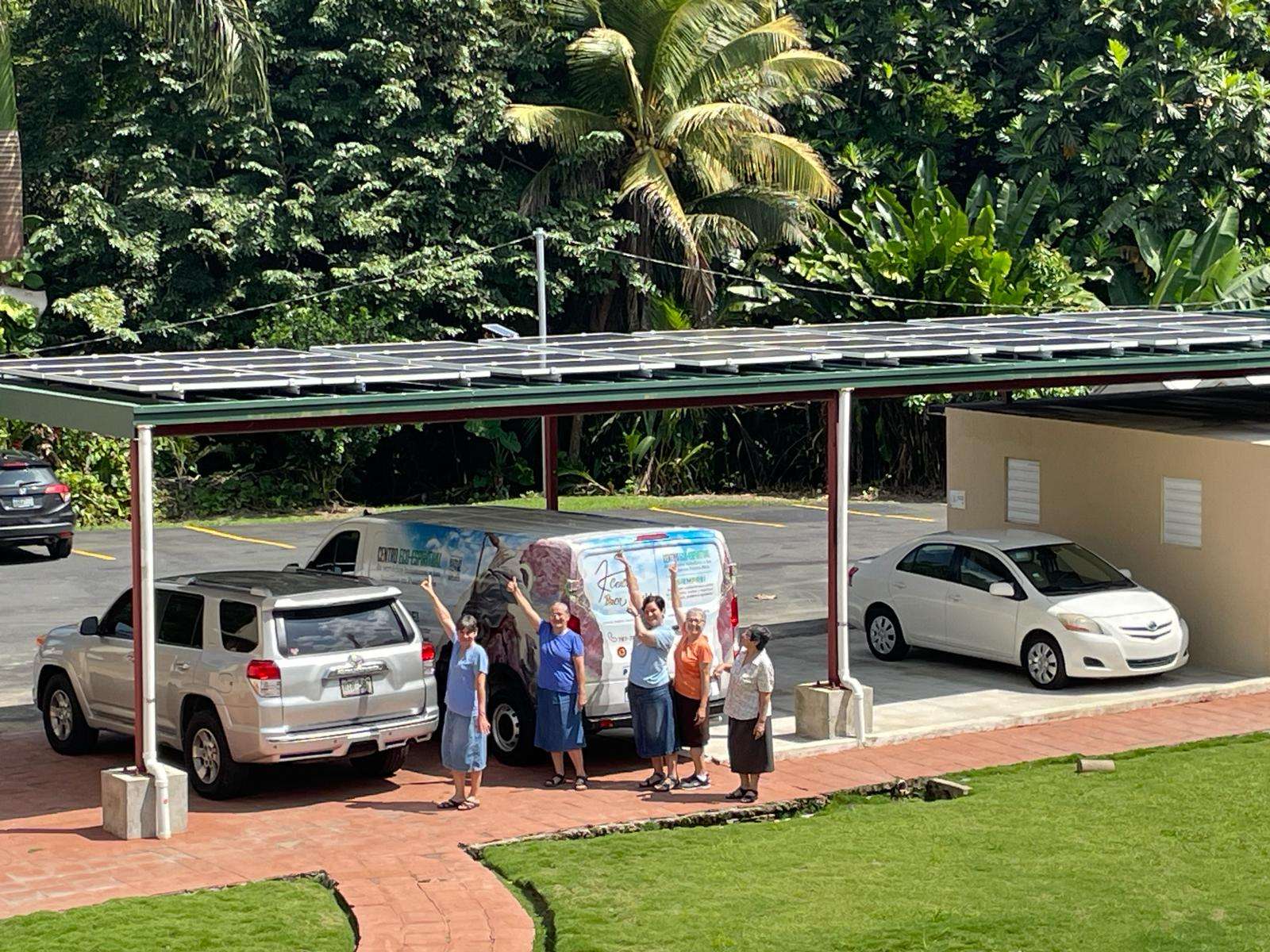 Buen Pastor solar carport with community members in Puerto Rico