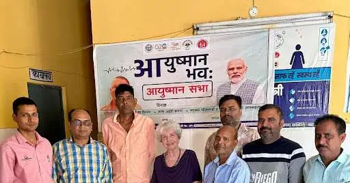 Janet with Indian partners at Ayushman Bhav clinic banner