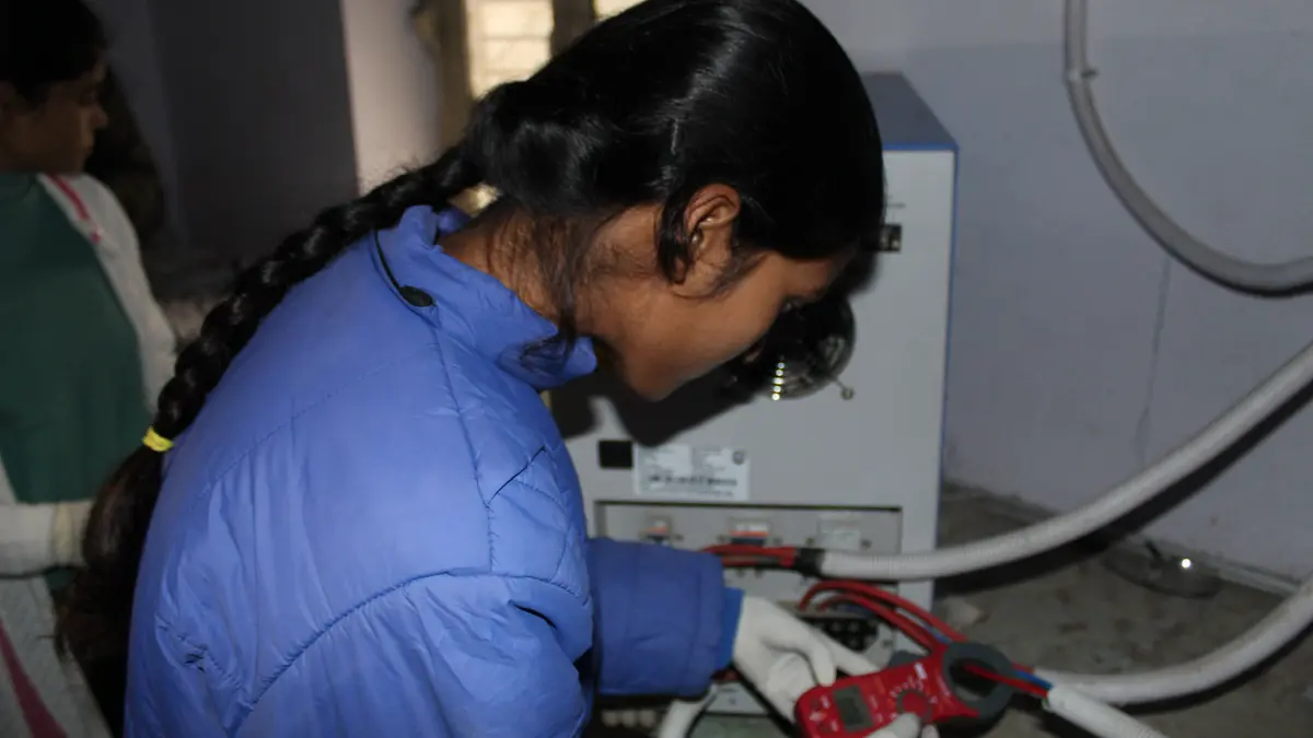 A trainee testing a battery during solar maintenance training